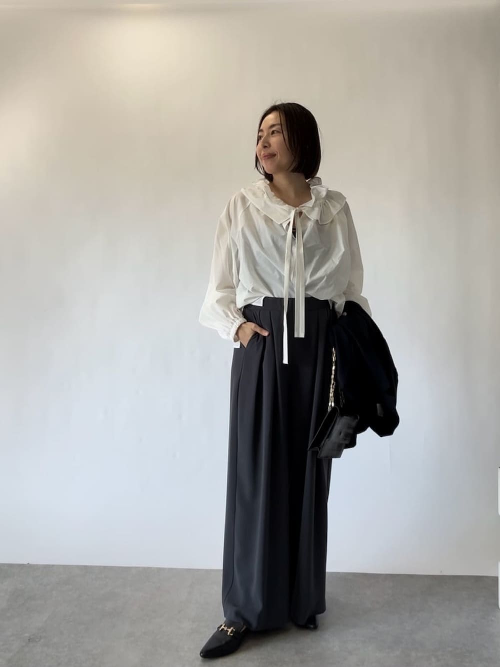 ブルー系のテーラードジャケット、ホワイト系のシャツ/ブラウス、グレー系のスラックスを着用したレディースの冬コーディネートの4枚目の写真