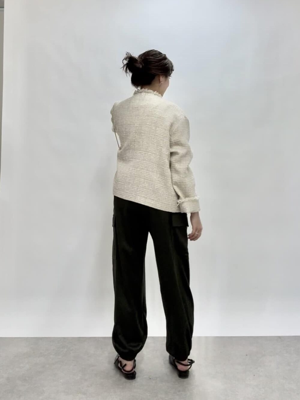 ベージュ系のノーカラージャケット、グリーン系のカーゴパンツ、ブラック系のパンプスを着用したレディースの冬コーディネートの3枚目の写真