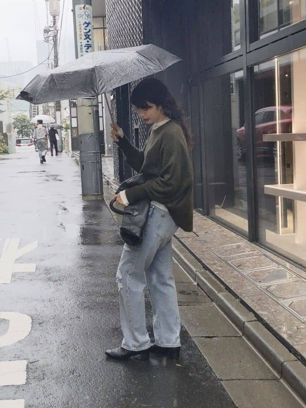 ブルー系のデニムパンツ、ホワイト系のTシャツ/カットソー、ブラック系のブーツを着用したレディースの秋コーディネートの2枚目の写真