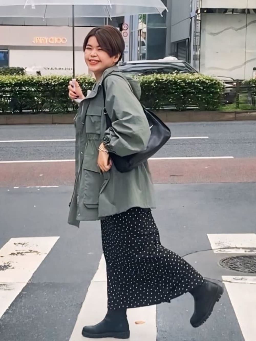 グリーン系のマウンテンパーカー、ブラック系のシャツ/ブラウス、ブラック系のスカートを着用したレディースの秋コーディネートの2枚目の写真