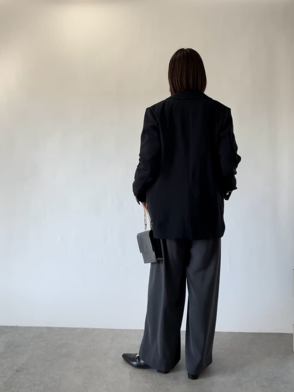 ブルー系のテーラードジャケット、ホワイト系のシャツ/ブラウス、グレー系のスラックスを着用したレディースの冬コーディネートの3枚目の写真