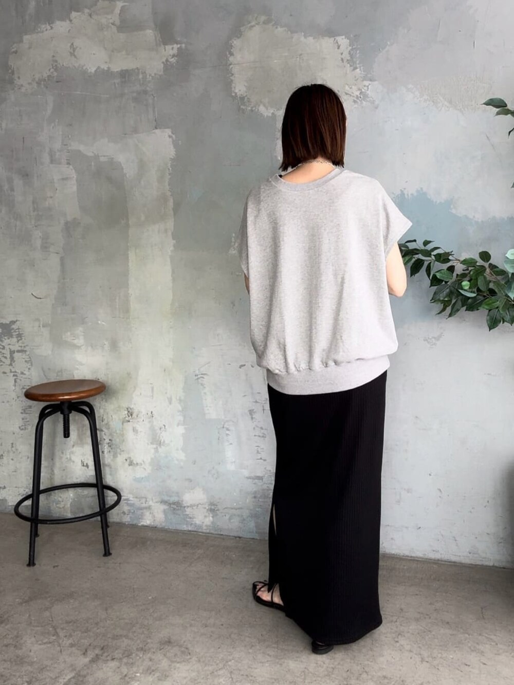 ブラック系のワンピース、ブラック系のサンダル、グレー系のTシャツ/カットソーを着用したレディースの春コーディネートの3枚目の写真