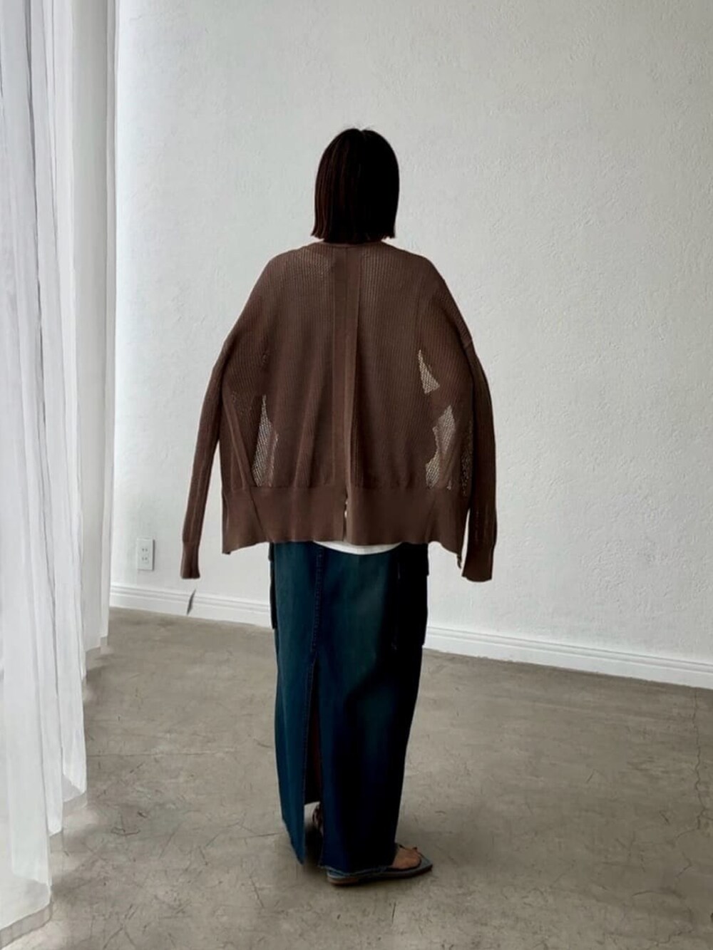 ホワイト系のシャツ/ブラウス、ブラウン系のカーディガン/ボレロ、ブルー系のデニムスカートを着用したレディースの春コーディネートの4枚目の写真