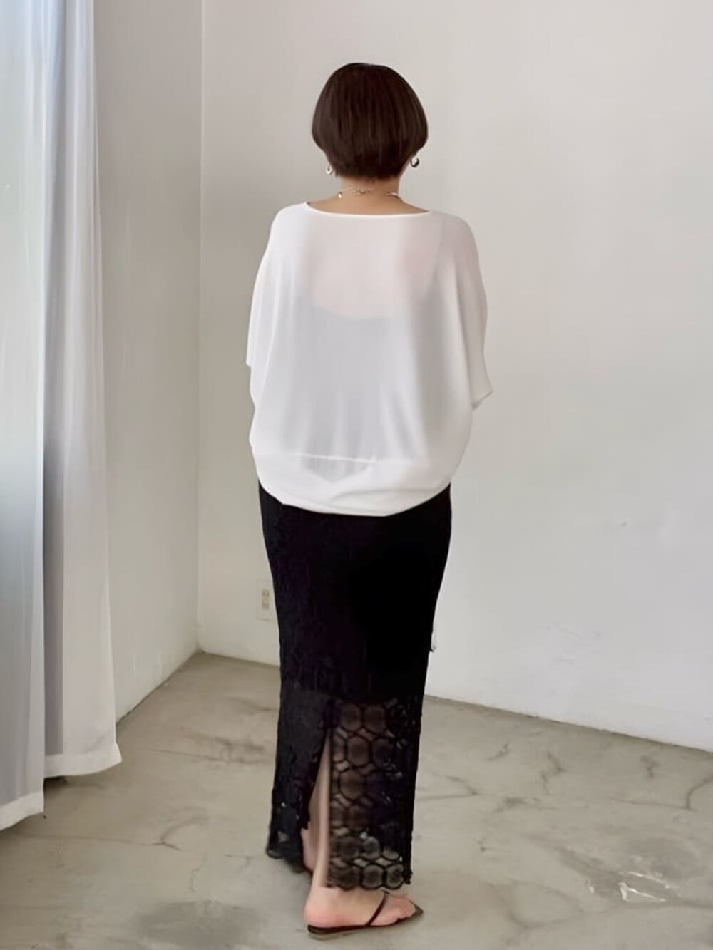 ホワイト系のシャツ/ブラウス、ブラック系のスカート、ブラック系のサンダルを着用したレディースの夏コーディネートの3枚目の写真