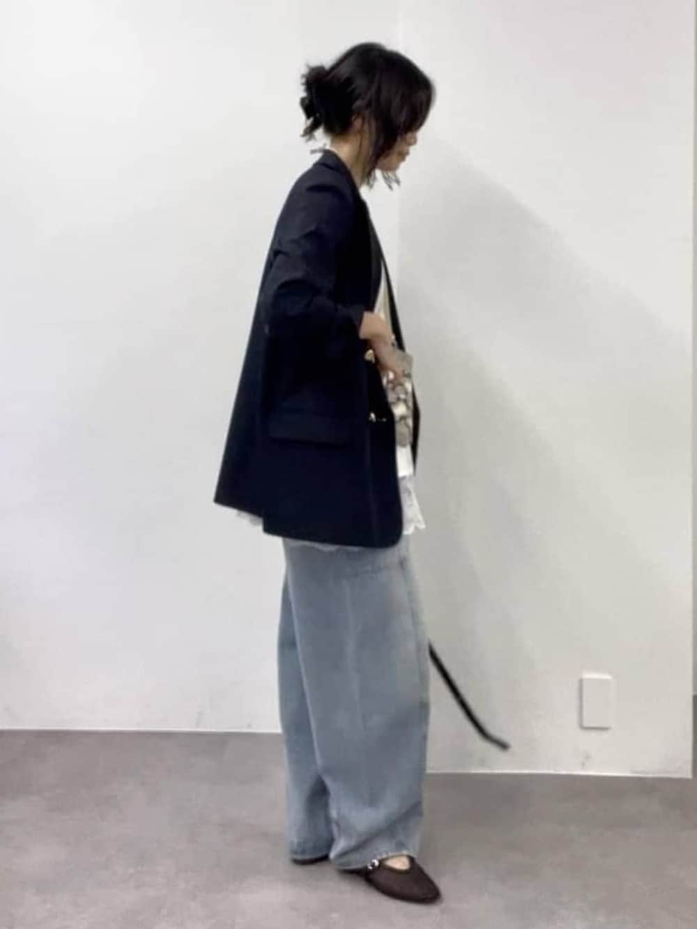 ホワイト系のキャミソール、ブルー系のデニムパンツ、ブラック系のその他シューズを着用したレディースの冬コーディネートの2枚目の写真