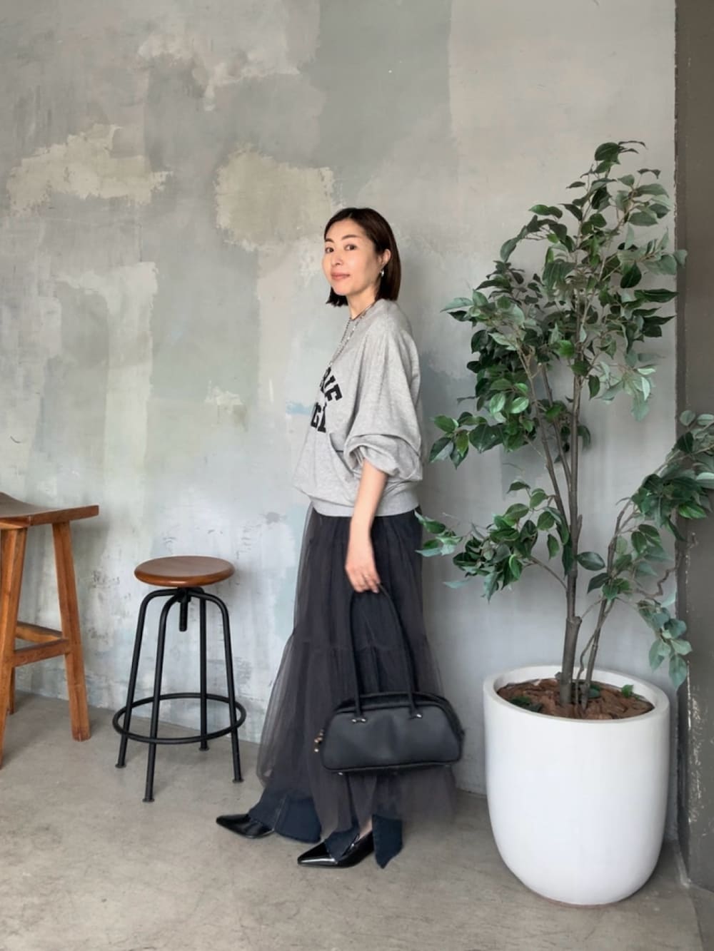 グレー系のスウェット、グレー系のスカートを着用したレディースの夏コーディネートの3枚目の写真