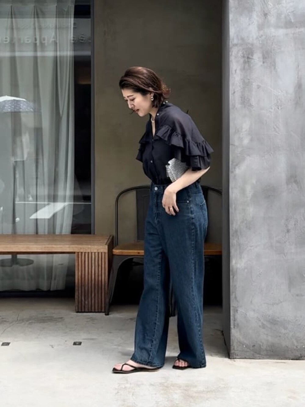 ブラック系のシャツ/ブラウス、ブルー系のデニムパンツを着用したレディースの夏コーディネートの3枚目の写真