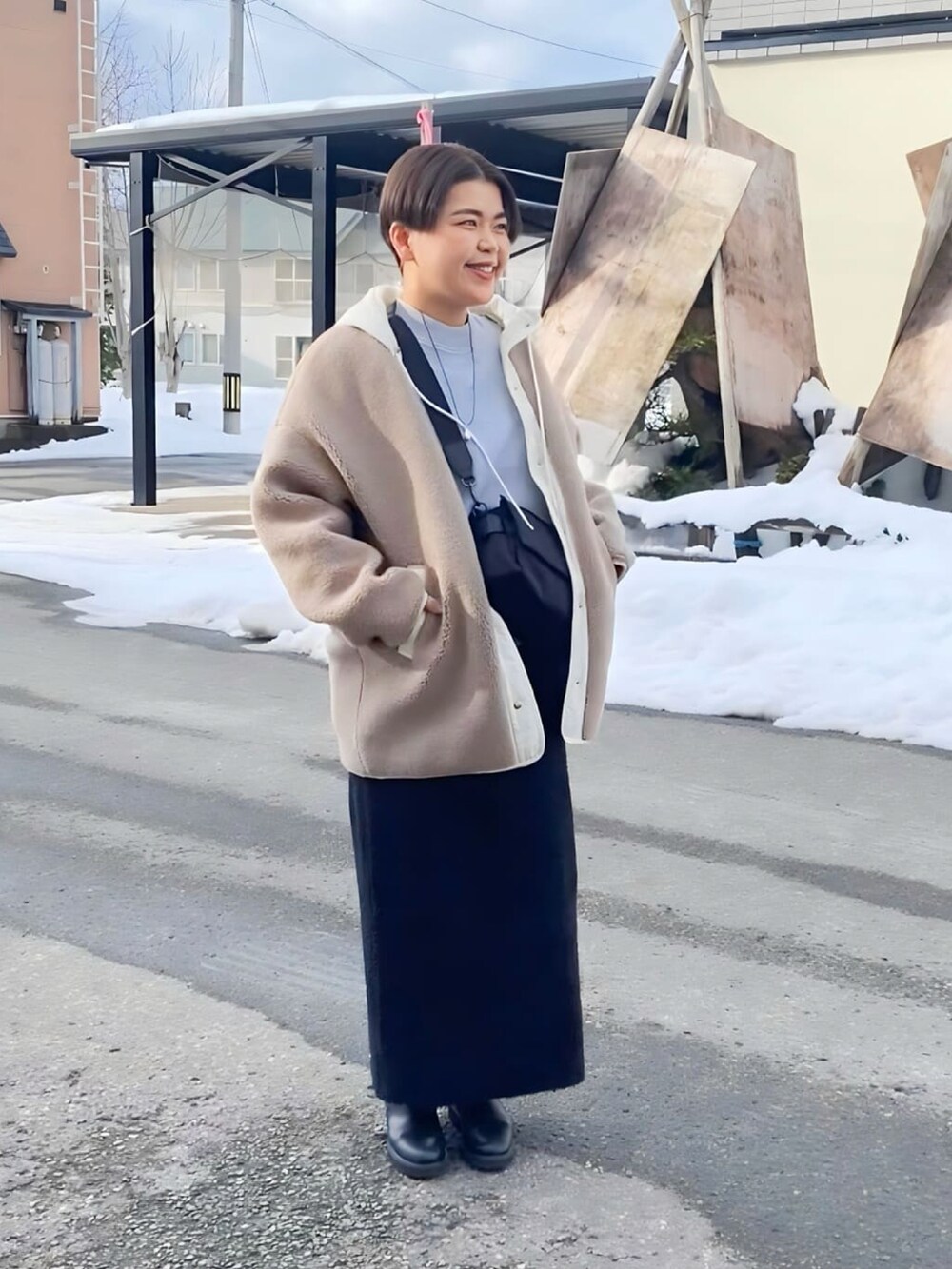 ブラック系のブーツ、グレー系のニット/セーター、ブラック系のスカートを着用したレディースの冬コーディネートの3枚目の写真