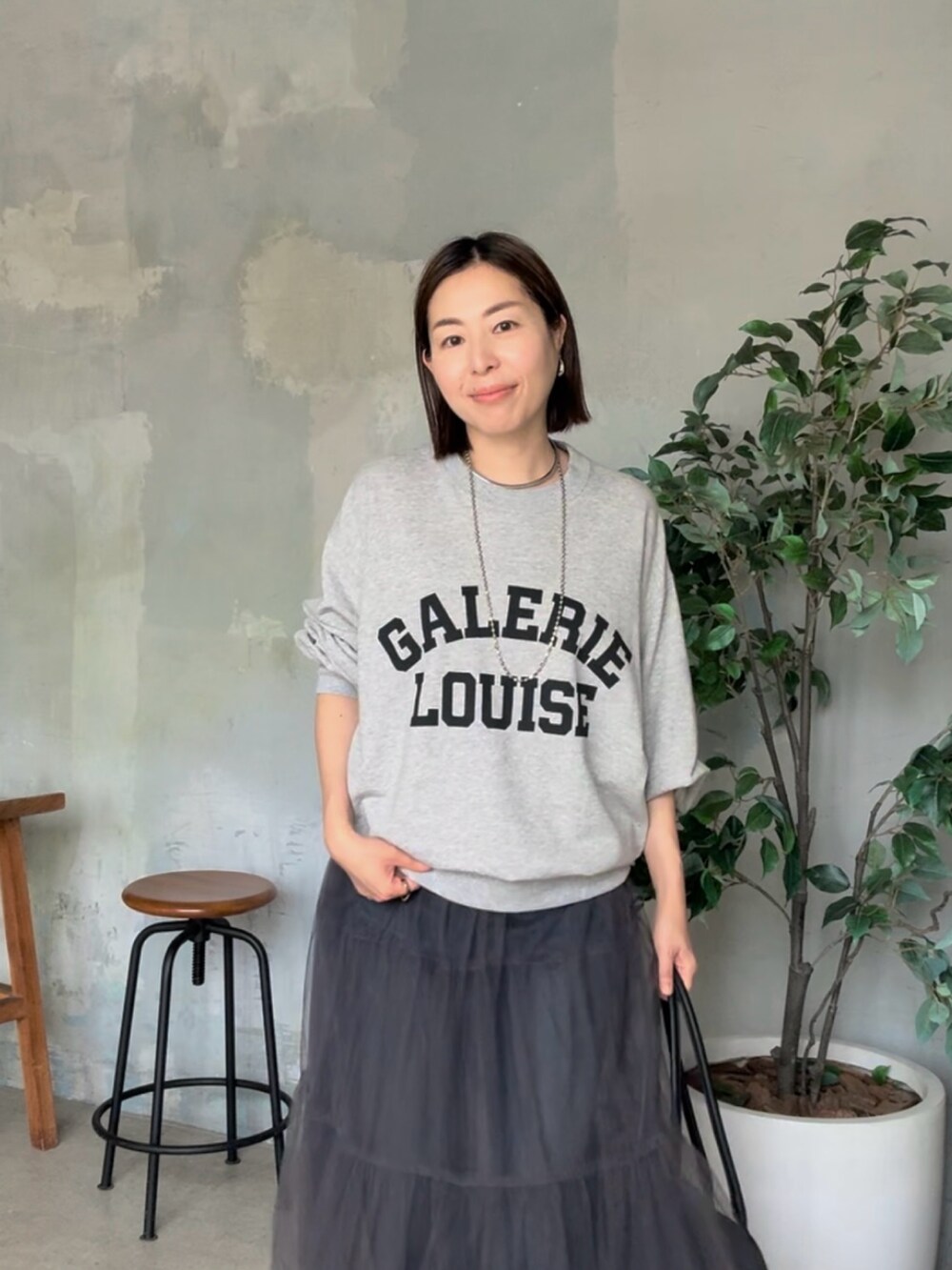 グレー系のスウェット、グレー系のスカートを着用したレディースの夏コーディネートの4枚目の写真