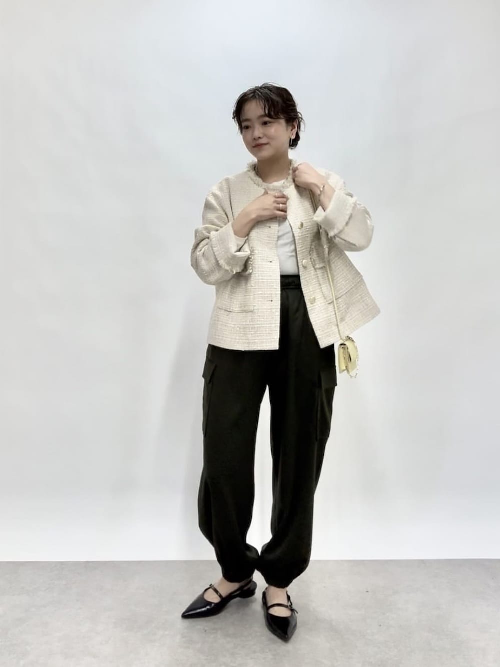 ベージュ系のノーカラージャケット、グリーン系のカーゴパンツ、ブラック系のパンプスを着用したレディースの冬コーディネートの2枚目の写真