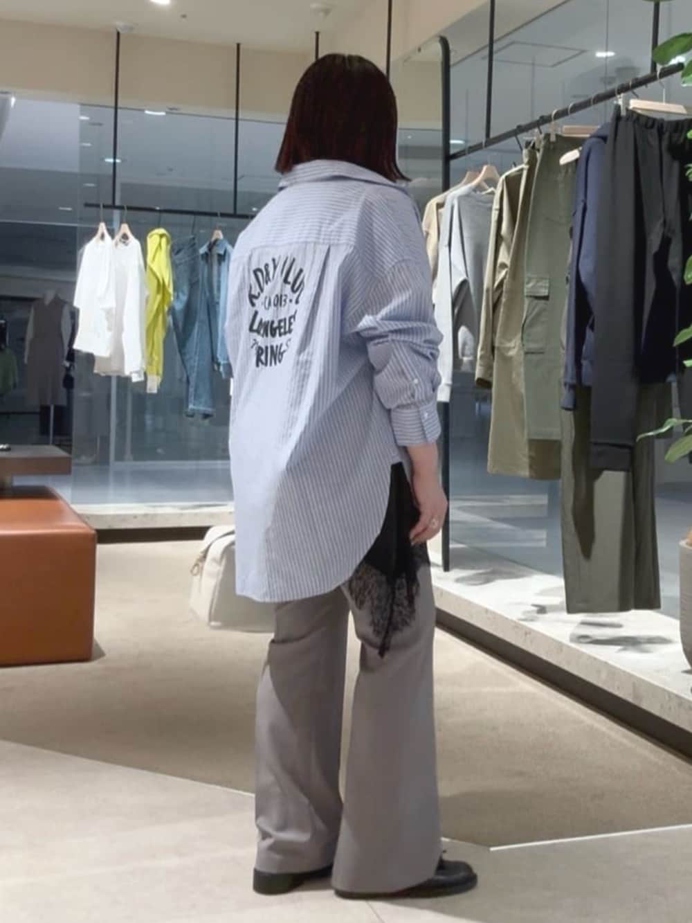 ホワイト系のボストンバッグ、ブルー系のシャツ/ブラウス、ブラック系のキャミソールを着用したレディースの春コーディネートの4枚目の写真