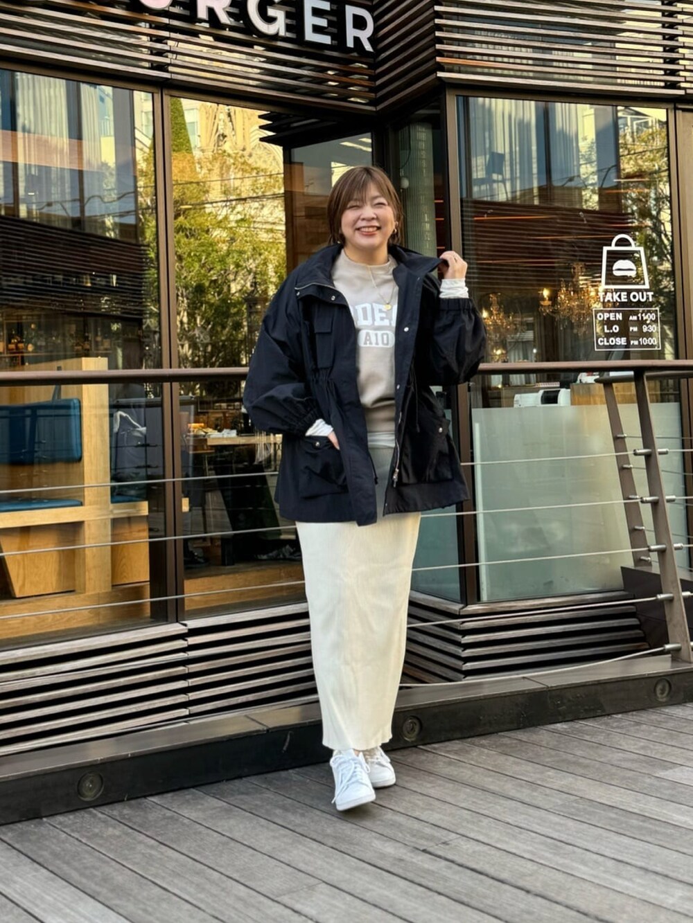 ブラック系のマウンテンパーカー、ベージュ系のスウェット、ベージュ系のスカートを着用したレディースの冬コーディネートの2枚目の写真