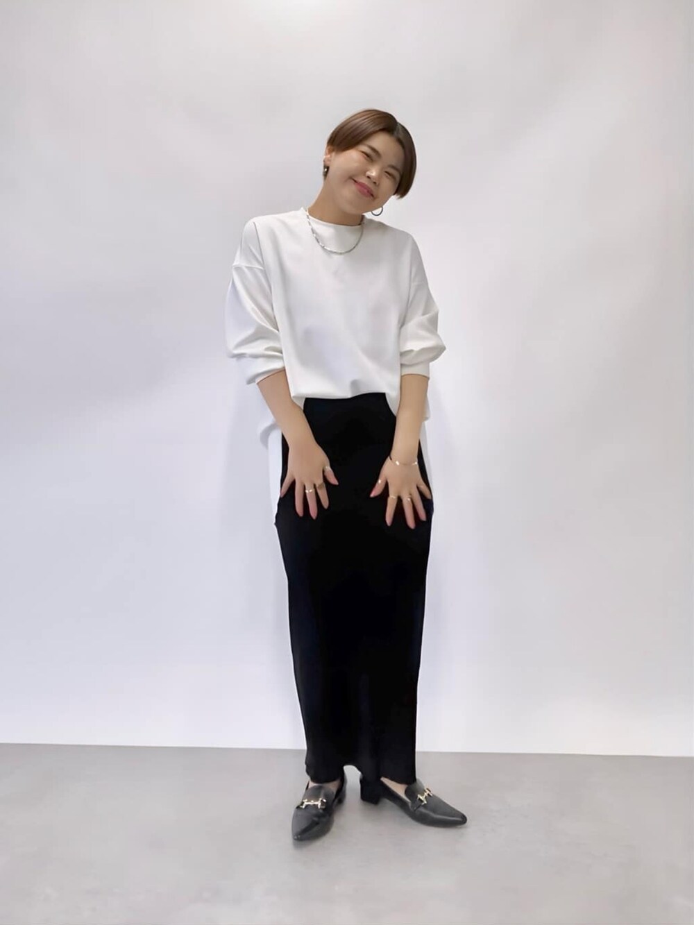 ホワイト系のTシャツ/カットソー、ブラック系のスカート、ブラック系のローファーを着用したレディースの冬コーディネートの2枚目の写真