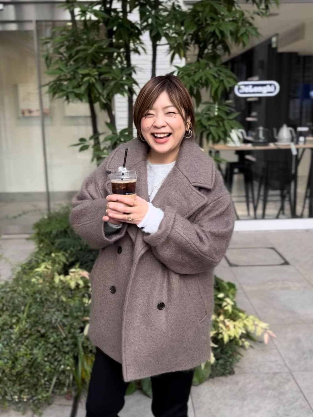 ブラウン系のその他アウター、ブラック系のスウェットパンツ、ブラック系のブーツを着用したレディースの冬コーディネートの4枚目の写真