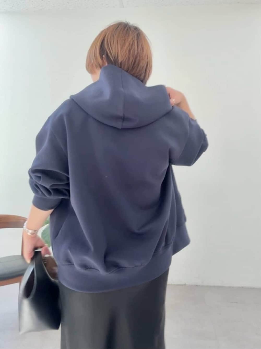 ブラック系のハンドバッグ、ブラック系のスカート、ブラック系のブーツを着用したレディースの冬コーディネートの4枚目の写真