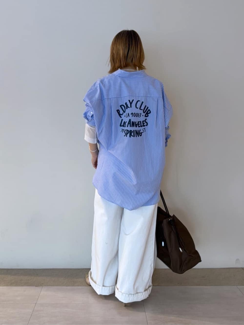 ベージュ系のパンプス、ホワイト系のTシャツ/カットソー、ホワイト系のデニムパンツを着用したレディースの冬コーディネートの3枚目の写真