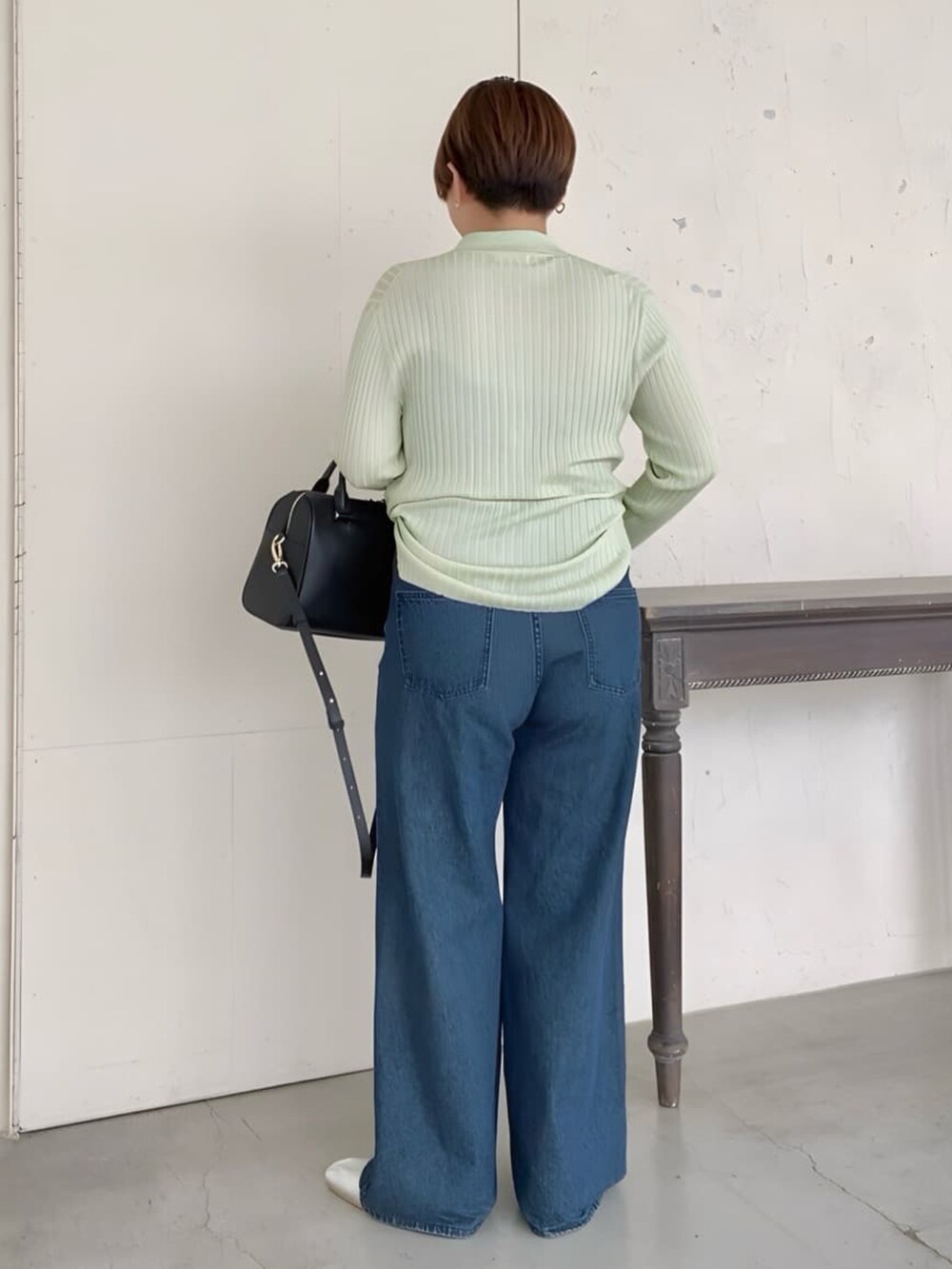 グリーン系のカーディガン/ボレロ、ブルー系のデニムパンツ、シルバー系のパンプスを着用したレディースの夏コーディネートの2枚目の写真