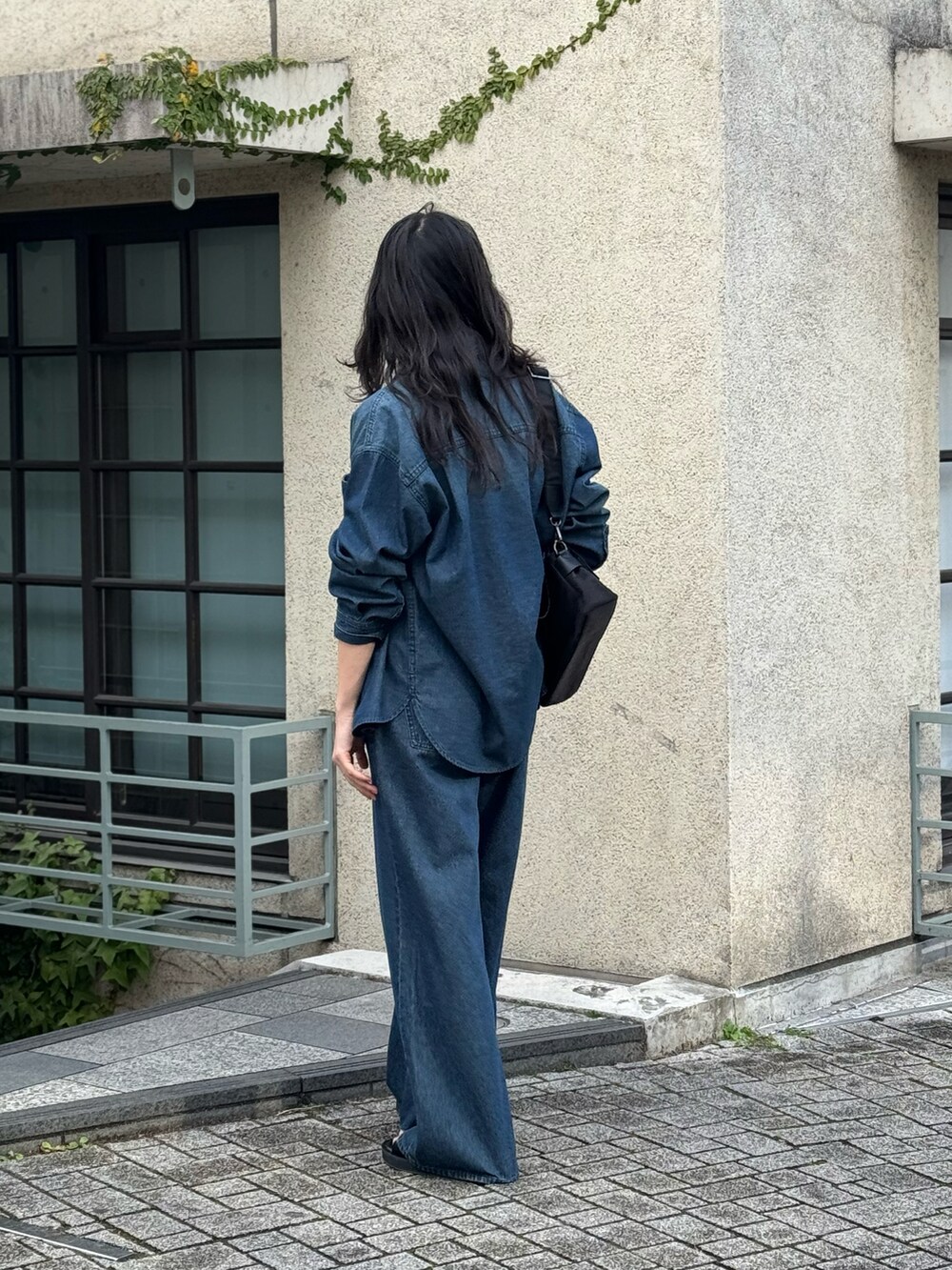 ブルー系のデニムパンツ、ブラック系のTシャツ/カットソー、ブルー系のシャツ/ブラウスを着用したレディースの春コーディネートの2枚目の写真