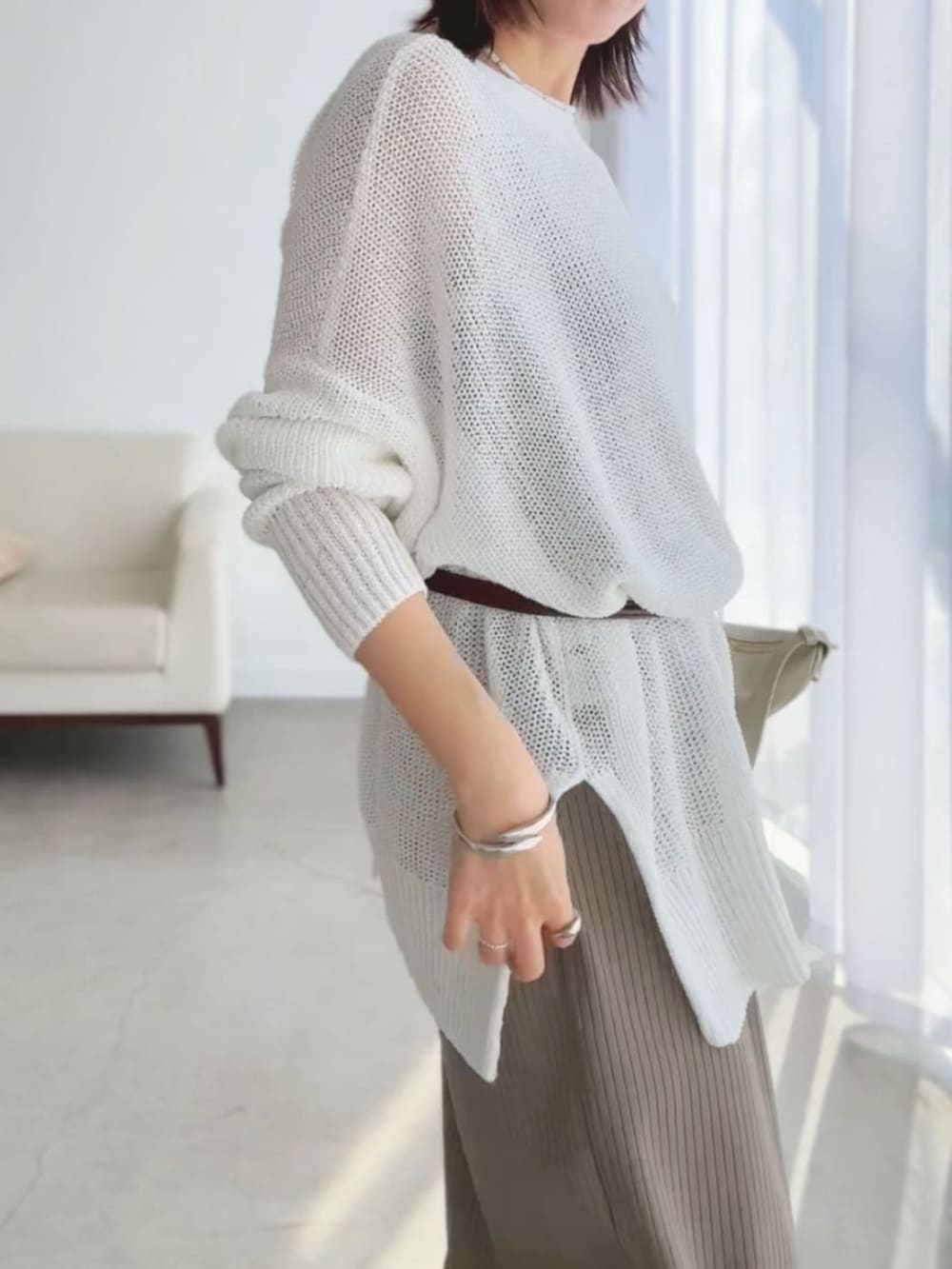 ブラウン系のその他シューズ、ゴールド系のショルダーバッグ、ホワイト系のカーディガン/ボレロを着用したレディースの春コーディネートの5枚目の写真