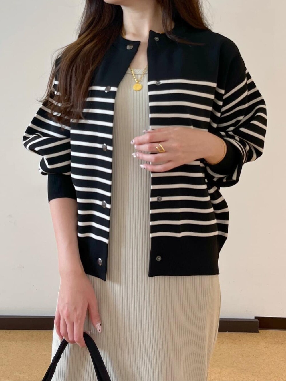 ベージュ系のワンピース、ブラック系のニット/セーターを着用したレディースの秋コーディネートの5枚目の写真