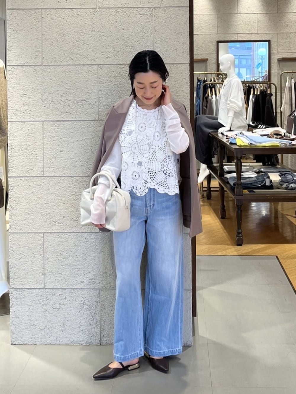 ブラウン系のテーラードジャケット、ホワイト系のニット/セーター、ブルー系のデニムパンツを着用したレディースの冬コーディネートの2枚目の写真