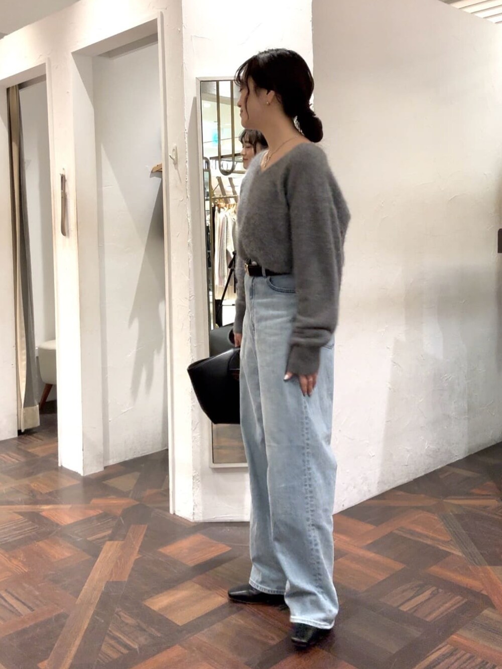 グレー系のニット/セーター、ブラック系のハンドバッグ、ブラック系のベルトを着用したレディースの冬コーディネートの3枚目の写真