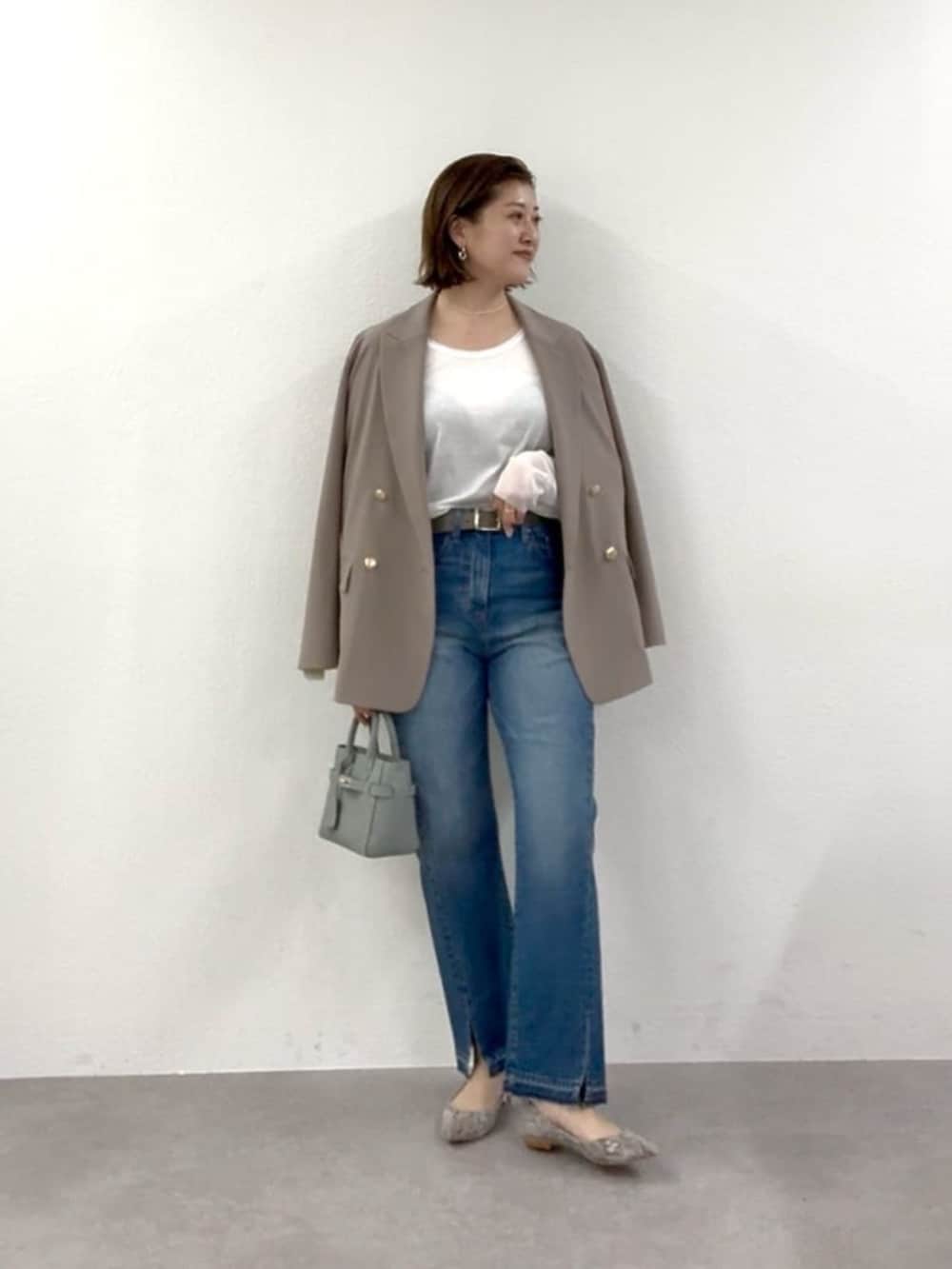 グレー系のパンプス、ブルー系のトートバッグ、ホワイト系のTシャツ/カットソーを着用したレディースの冬コーディネートの2枚目の写真