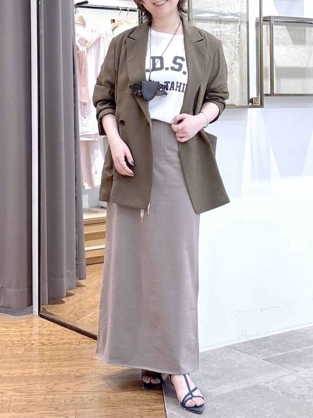 ホワイト系のTシャツ/カットソー、ブラウン系のテーラードジャケット、ブルー系のサンダルを着用したレディースの春コーディネートの5枚目の写真