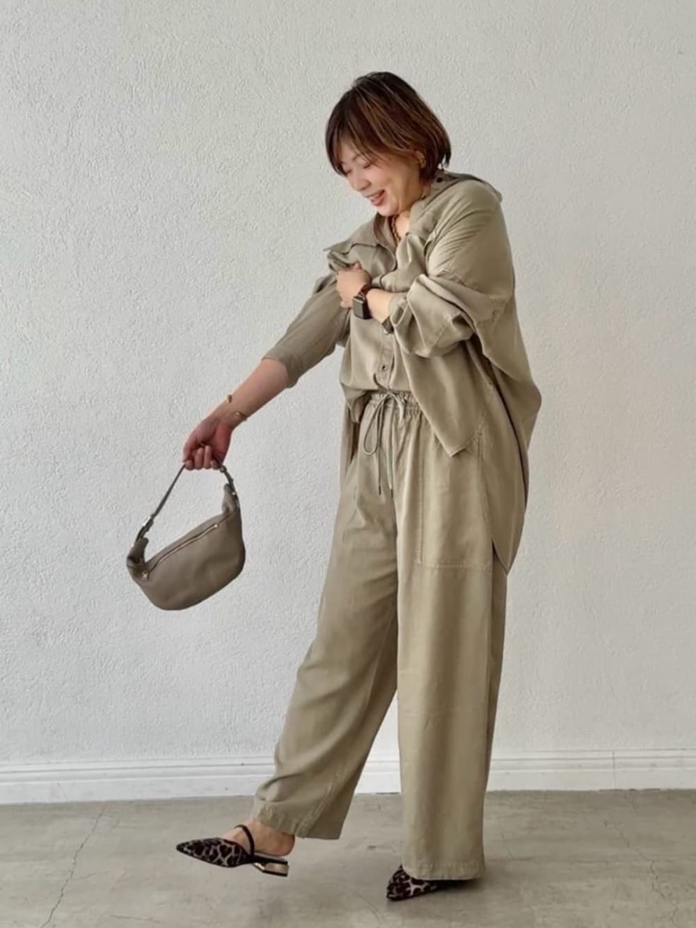 ベージュ系のその他シューズ、グリーン系のシャツ/ブラウス、ベージュ系のショルダーバッグを着用したレディースの春コーディネートの6枚目の写真