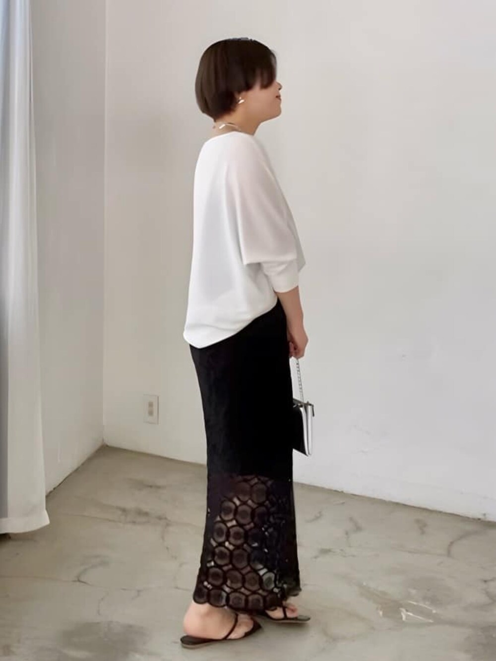 ホワイト系のシャツ/ブラウス、ブラック系のスカート、ブラック系のサンダルを着用したレディースの夏コーディネートの2枚目の写真