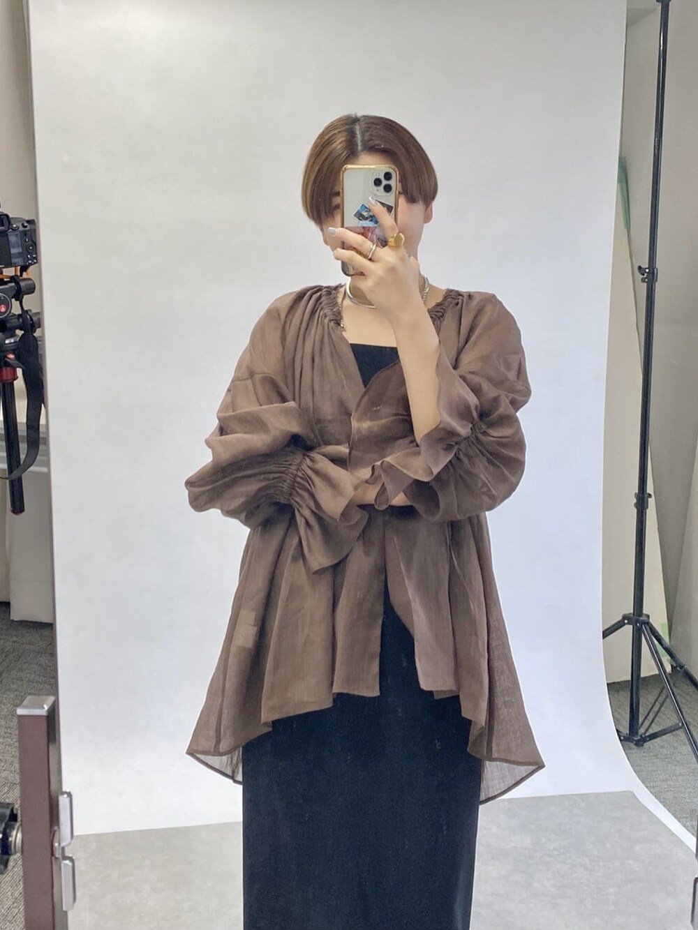 ブラック系のワンピース、シルバー系のサンダル、ベージュ系のシャツ/ブラウスを着用したレディースの春コーディネートの2枚目の写真