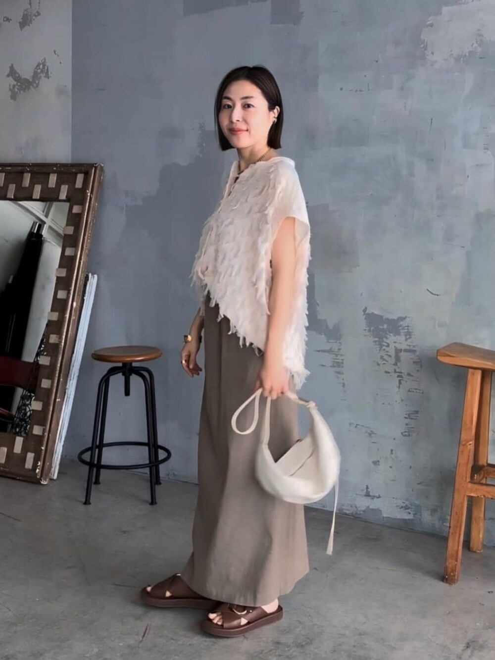 ホワイト系のシャツ/ブラウス、ブラウン系のサンダル、ホワイト系のボディバッグ/ウエストポーチを着用したレディースの夏コーディネートの2枚目の写真