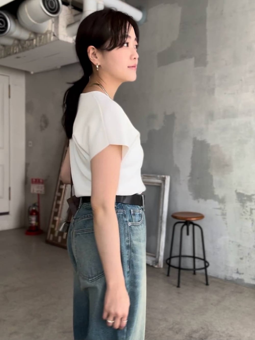 ホワイト系のニット/セーター、ブルー系のデニムパンツ、ブラック系のサンダルを着用したレディースの春コーディネートの3枚目の写真