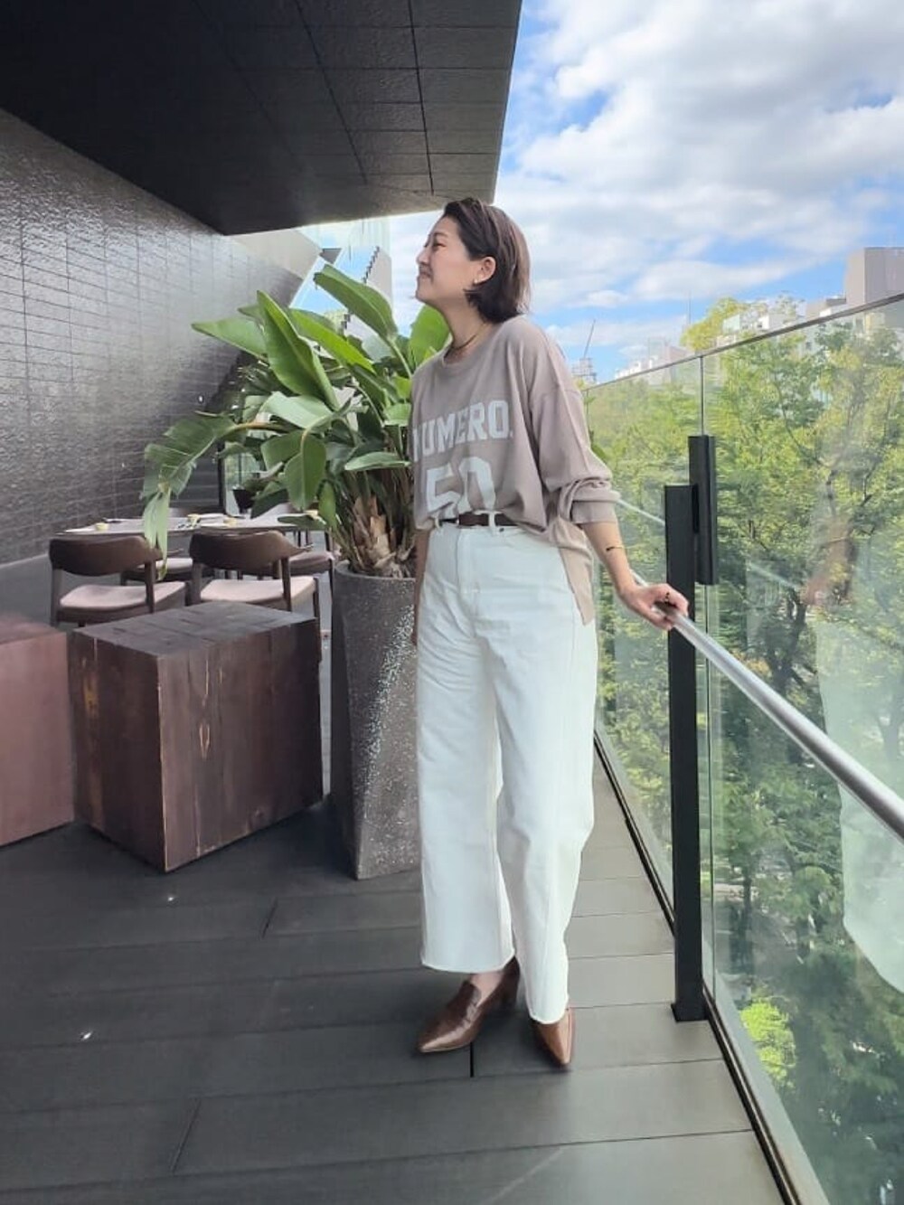 ベージュ系のニット/セーター、ホワイト系のデニムパンツ、ブラウン系のローファーを着用したレディースの秋コーディネートの3枚目の写真