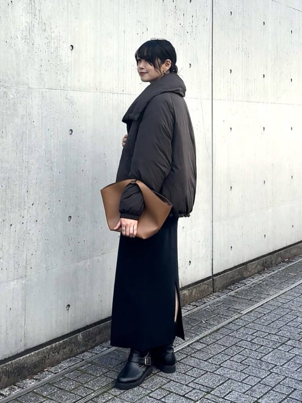 ブラウン系のダウンジャケット/コート、イエロー系のハンドバッグ、ブルー系のスカートを着用したレディースの秋コーディネートの3枚目の写真