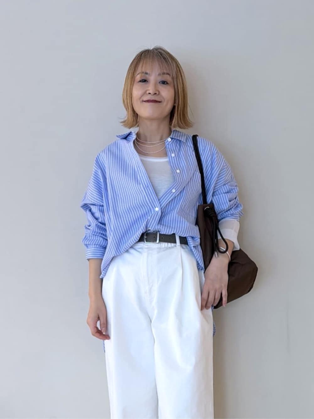 ベージュ系のパンプス、ホワイト系のTシャツ/カットソー、ホワイト系のデニムパンツを着用したレディースの冬コーディネートの4枚目の写真