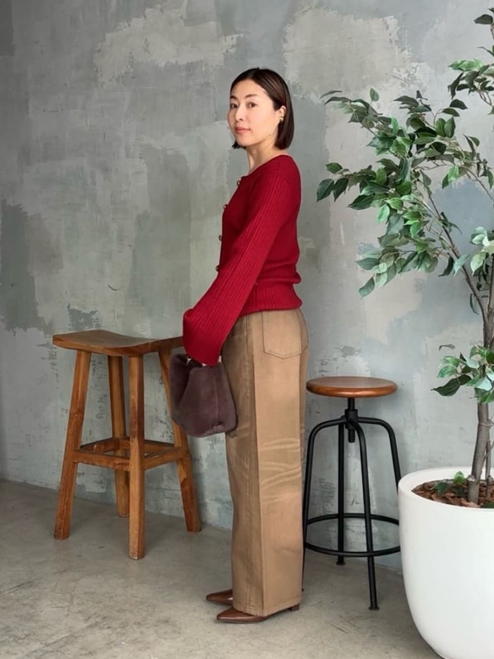 レッド系のカーディガン/ボレロ、ブラウン系のデニムパンツ、ブラウン系のハンドバッグを着用したレディースの夏コーディネートの2枚目の写真