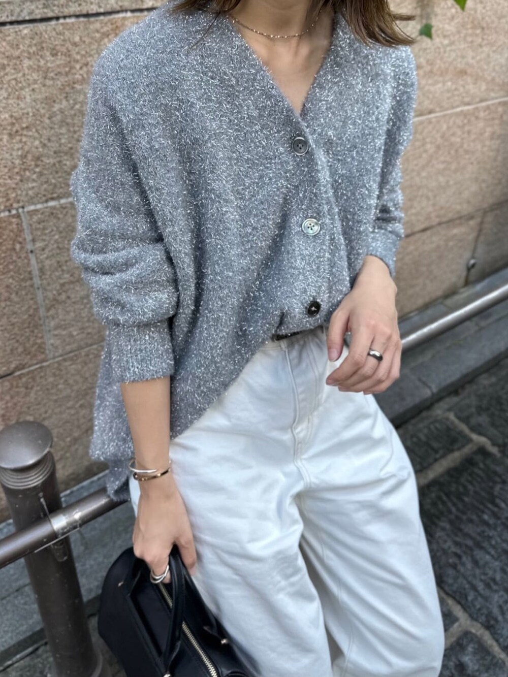 グレー系のカーディガン/ボレロ、ホワイト系のデニムパンツ、ブラック系のボストンバッグを着用したレディースの秋コーディネートの3枚目の写真