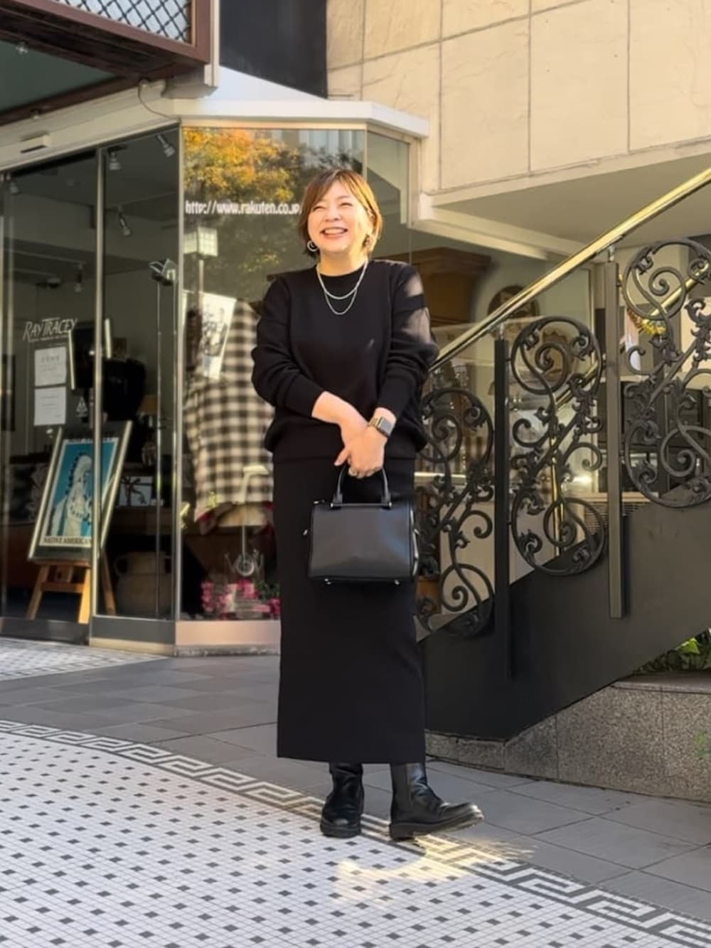 ブルー系のニット/セーター、ブルー系のスカート、ブラック系のボストンバッグを着用したレディースの冬コーディネートの3枚目の写真