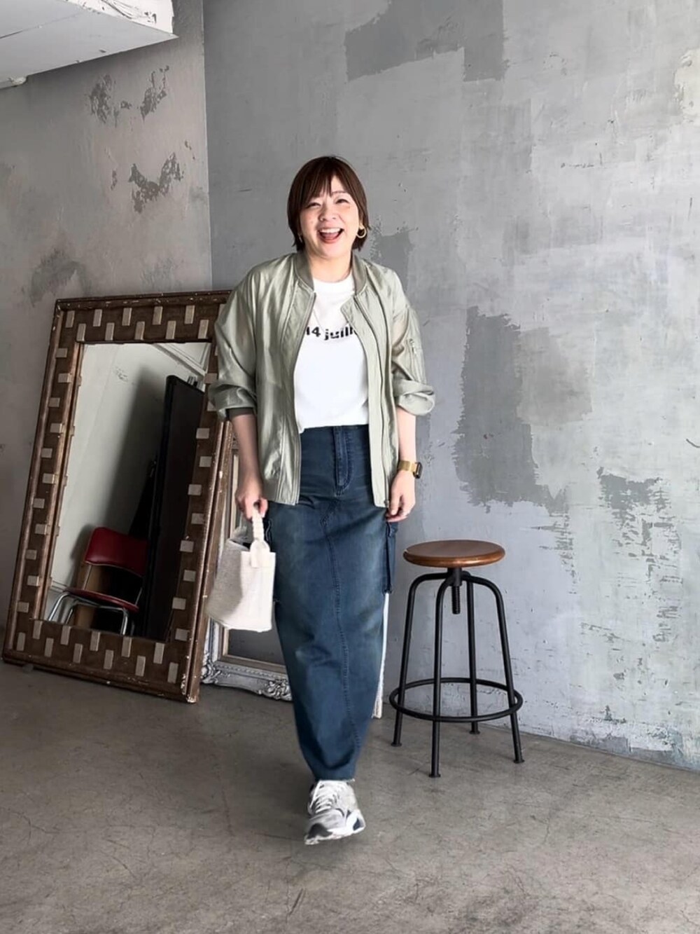 ホワイト系のシャツ/ブラウス、グリーン系のブルゾン、ブラック系のハンドバッグを着用したレディースの春コーディネートの2枚目の写真