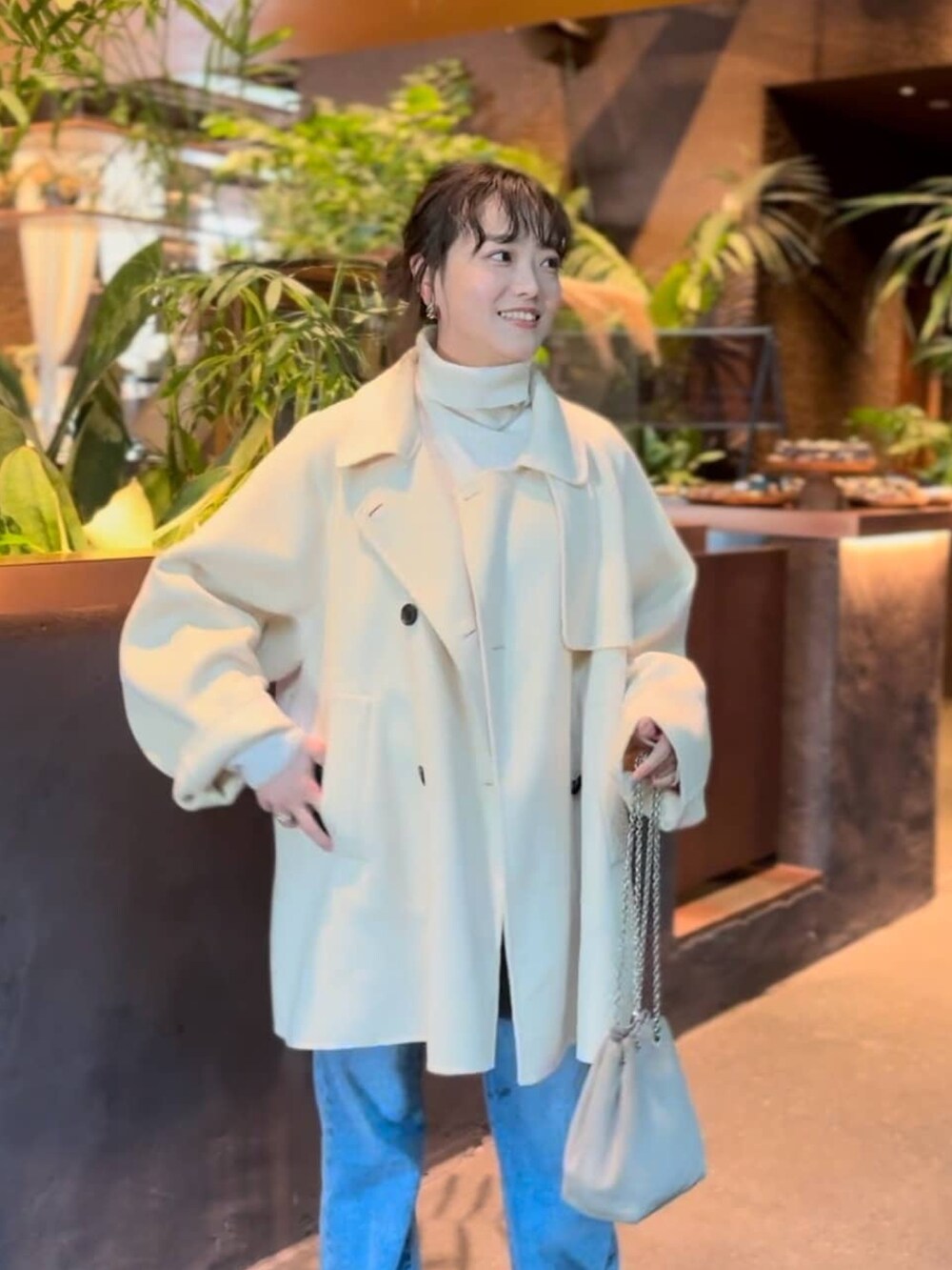 ベージュ系のその他アウター、ブルー系のデニムパンツ、ホワイト系のニット/セーターを着用したレディースの冬コーディネートの3枚目の写真