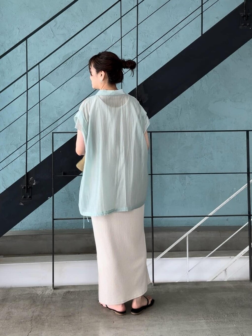 ホワイト系のワンピース、ブラック系のサンダル、グリーン系のシャツ/ブラウスを着用したレディースの春コーディネートの4枚目の写真