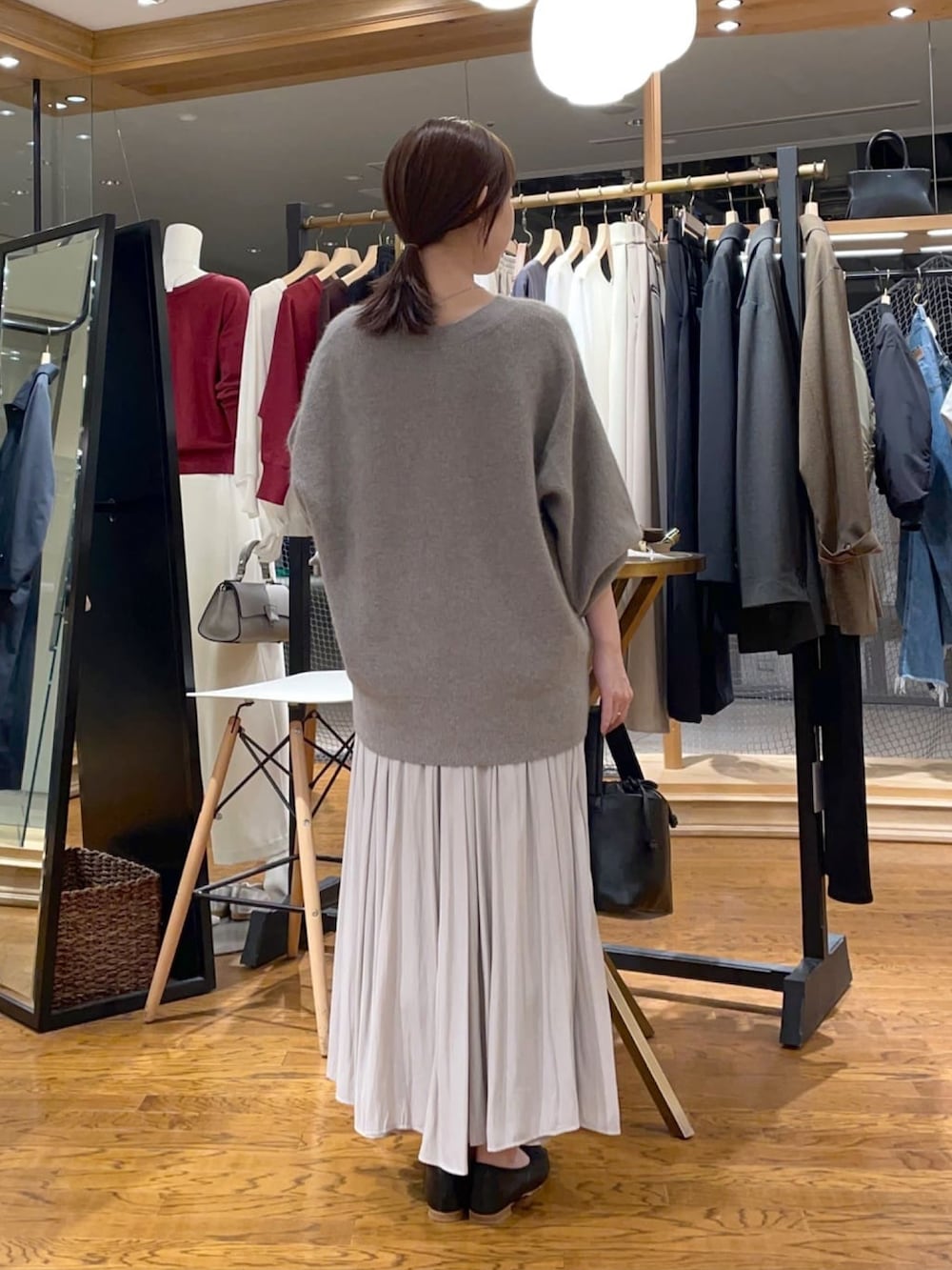 ブラウン系のカーディガン/ボレロ、ベージュ系のスカート、ブラック系のハンドバッグを着用したレディースの冬コーディネートの4枚目の写真