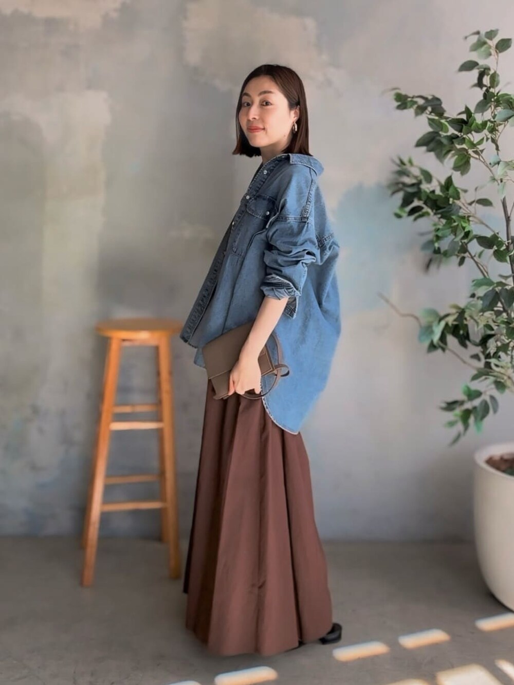 ブルー系のシャツ/ブラウス、ブラウン系のワンピース、ブラック系のサンダルを着用したレディースの春コーディネートの2枚目の写真