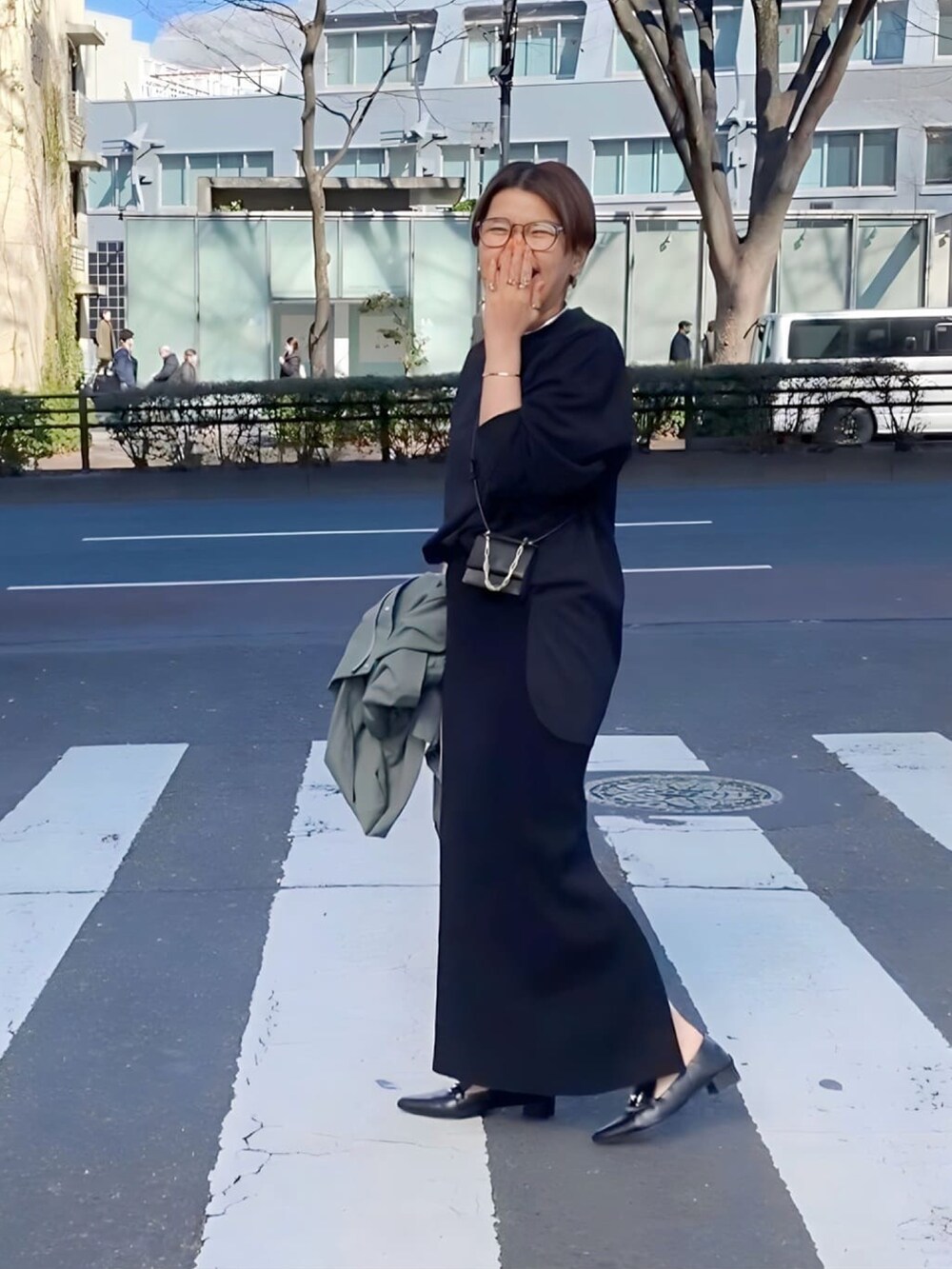 グレー系のスカート、ブラック系のTシャツ/カットソー、ブラック系のローファーを着用したレディースの冬コーディネートの3枚目の写真