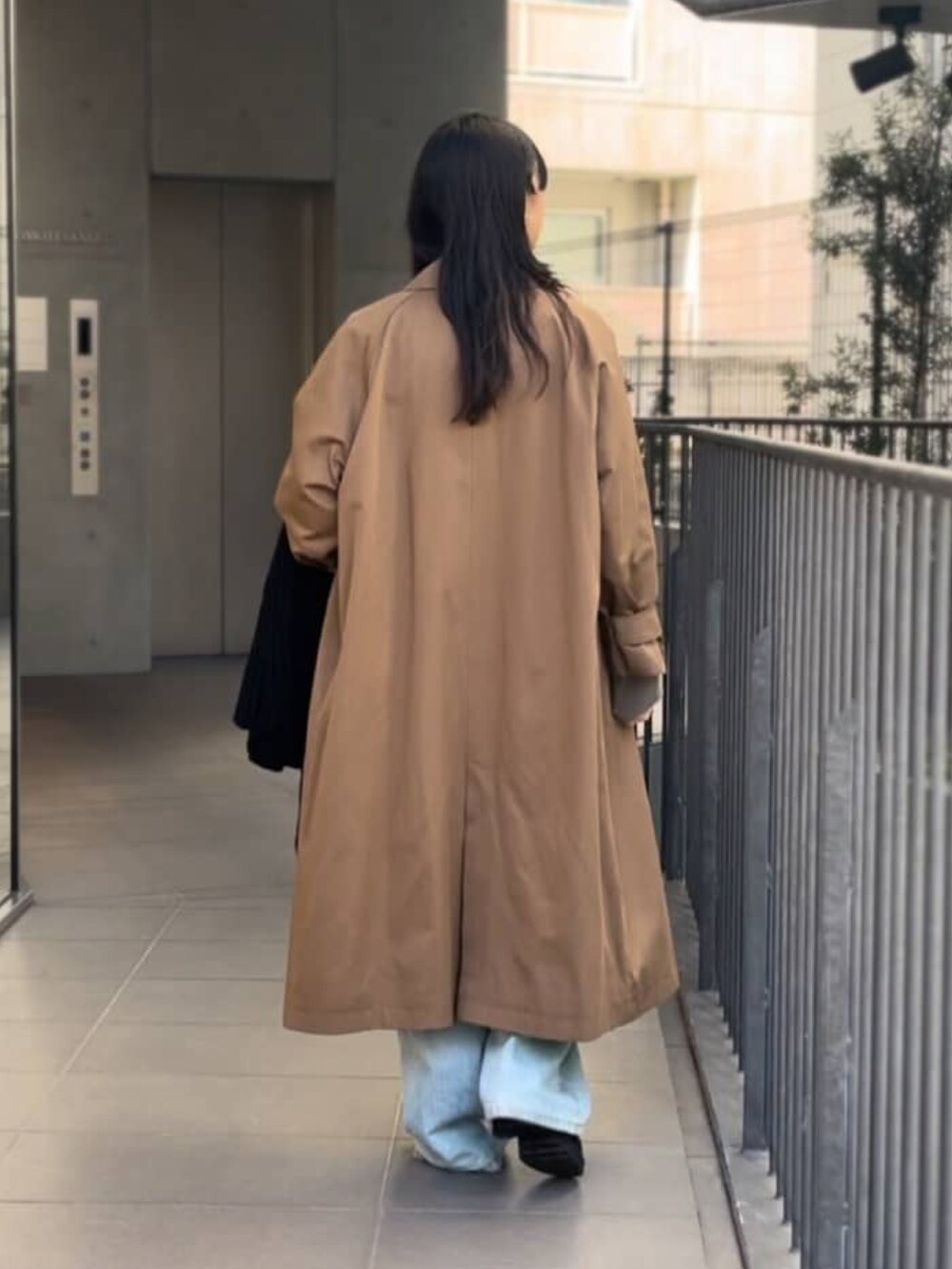 ベージュ系のニット/セーター、ブルー系のデニムパンツ、ブラウン系のステンカラーコートを着用したレディースの冬コーディネートの3枚目の写真