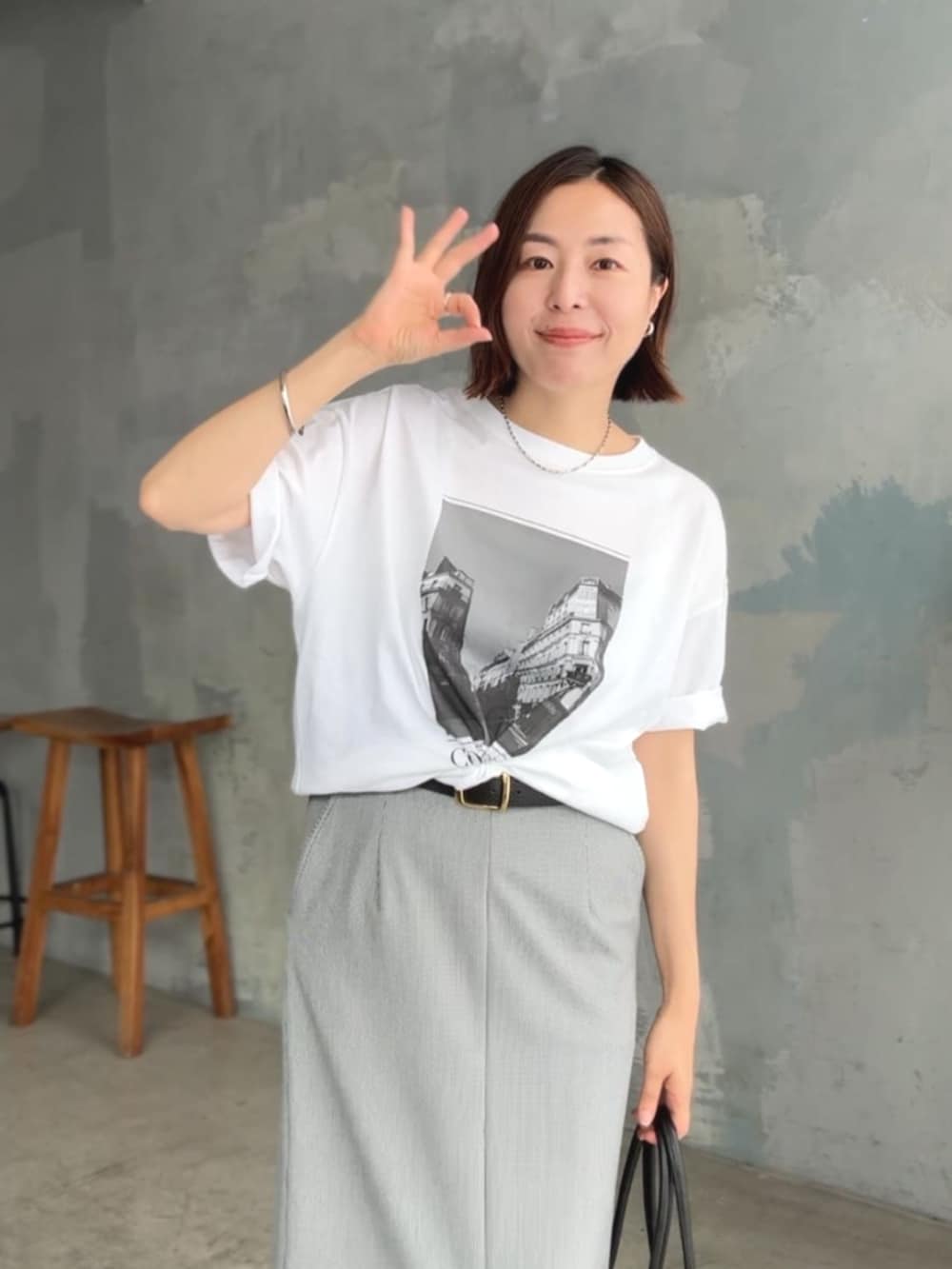 ホワイト系のTシャツ/カットソー、ホワイト系のサンダル、ブラック系のスカートを着用したレディースの夏コーディネートの4枚目の写真