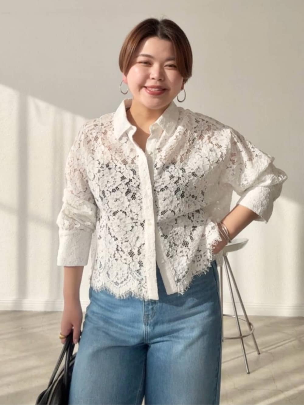 ブラック系のボストンバッグ、ブルー系のデニムパンツ、ベージュ系のその他シューズを着用したレディースの春コーディネートの3枚目の写真