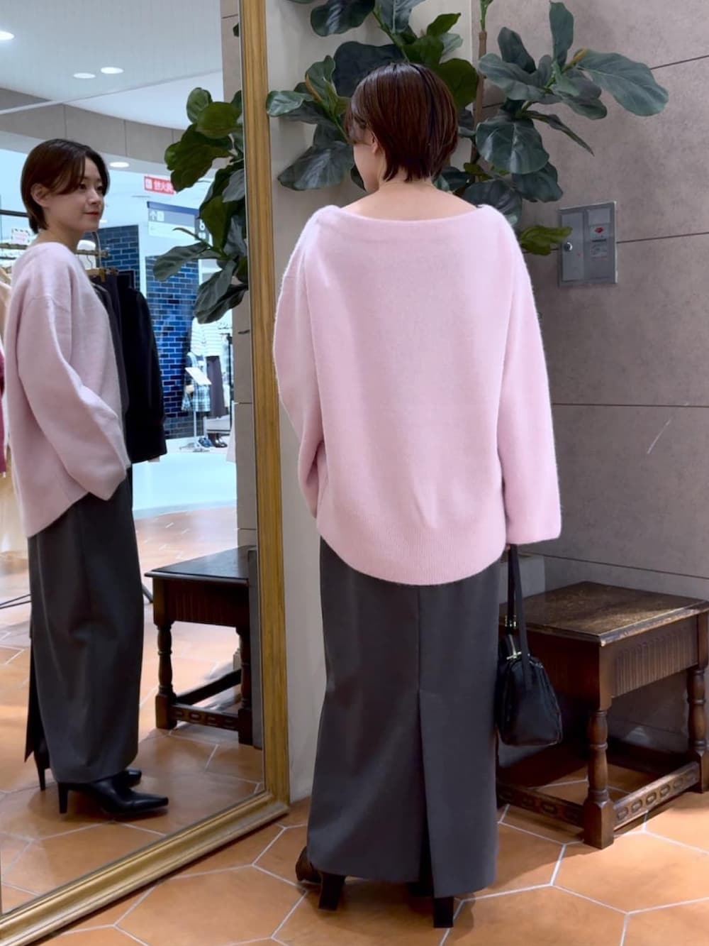 ピンク系のニット/セーター、グレー系のスカート、ブラック系のブーツを着用したレディースの秋コーディネートの3枚目の写真