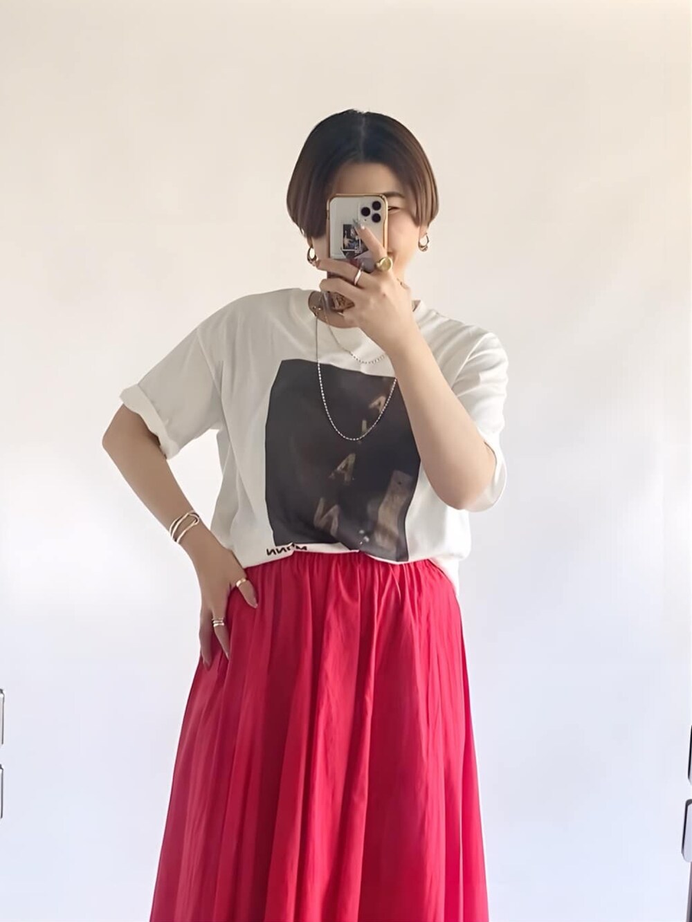 ブラウン系のTシャツ/カットソー、レッド系のスカート、シルバー系のサンダルを着用したレディースの夏コーディネートの2枚目の写真